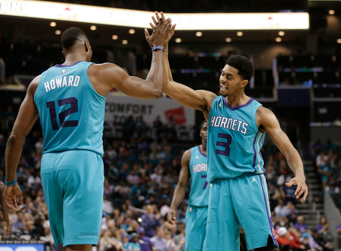 Charlotte Hornets' Jeremy Lamb (3) celebrates with Dwight Howard (12) after a basket against the Atlanta Hawks during the second half of an NBA basketball game in Charlotte, N.C., Friday, Oct. 20, 2017. (AP Photo/Chuck Burton)