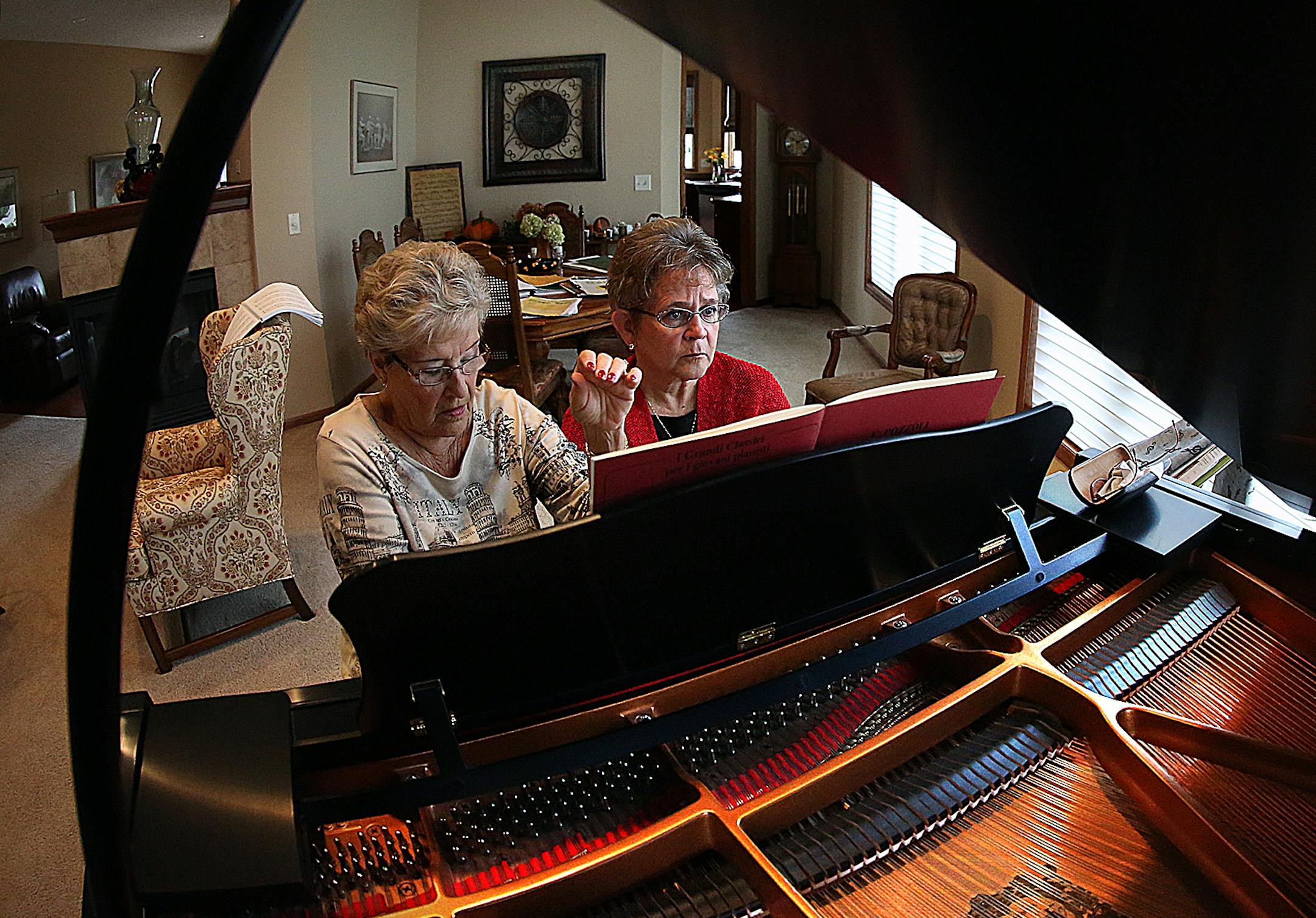 Mary Ann Papke, left, and Maureen Armstrong share a bench and a strong passion for the piano. They play duets weekly.