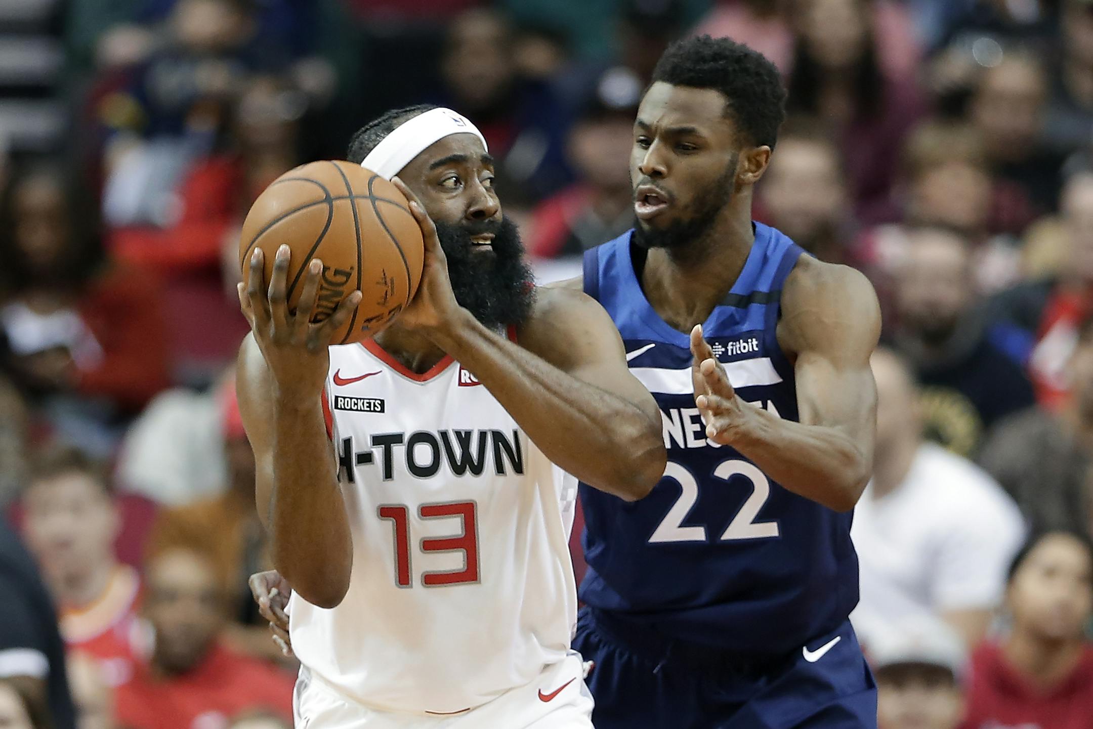 Houston Rockets guard James Harden (13) looks to pass the ball under pressure from Minnesota Timberwolves forward Andrew Wiggins (22) during the first half of an NBA basketball game Saturday, Jan. 11, 2020, in Houston. (AP Photo/Michael Wyke)