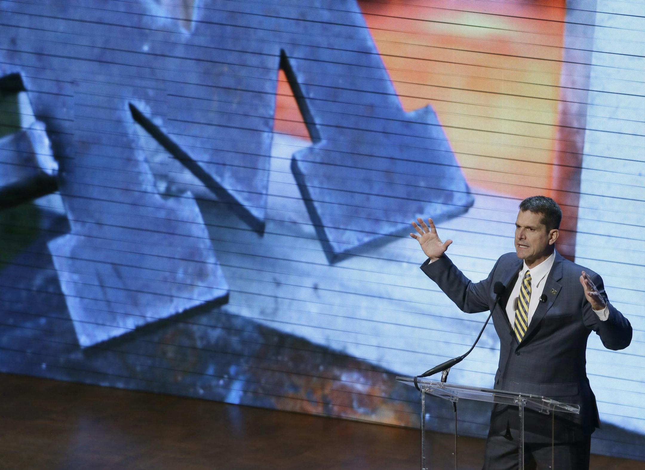 Michigan football coach Jim Harbaugh talks to fans at the Signing With the Stars spectacle, Wednesday, Feb. 3, 2016 in Ann Arbor, Mich. College football's recruiting circus has found its ringmaster in Michigan's coach. Harbaugh was the real star of the Wolverines show that former coach Lou Holtz predicted will be copied in years to come by other schools. (AP Photo/Carlos Osorio)