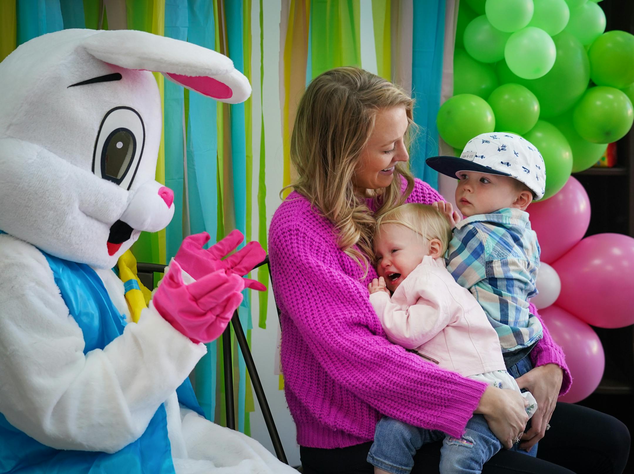 Sarah Urban and her children Mason, 2, and Kinley, 18 months, sit next to the Easter Bunny for a photo.