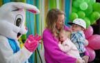 Sarah Urban and her children Mason, 2, and Kinley, 18 months, sit next to the Easter Bunny for a photo.