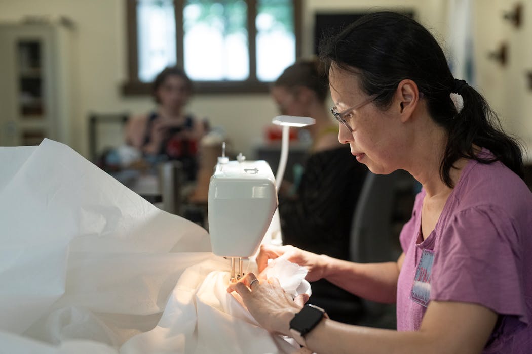 Mai Lauer repairs a torn dust ruffle during Re-Use Minnesota's Mend It Clinic at Franklin Library on June 12, 2024.