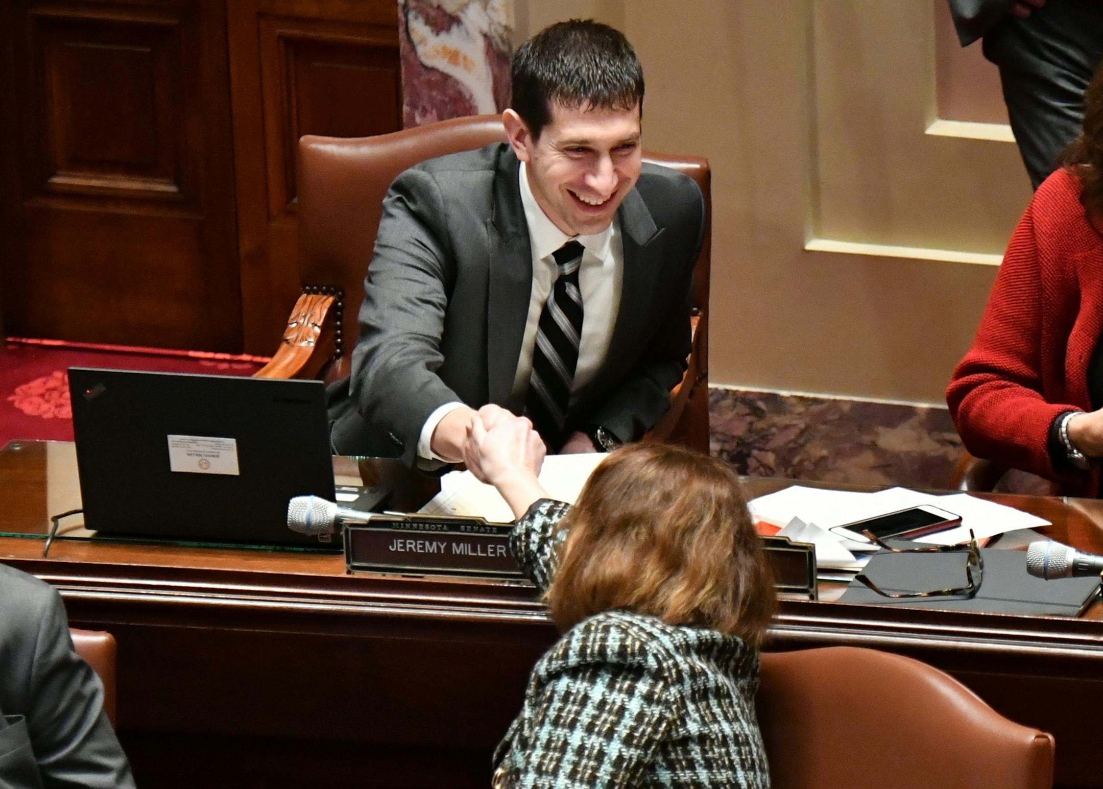 Sen. Jeremy Miller,R-Winona, chief author of the Sunday liquor bill is congratulated by other Senators. Sunday Liquor bill passes the Senate 38-28.