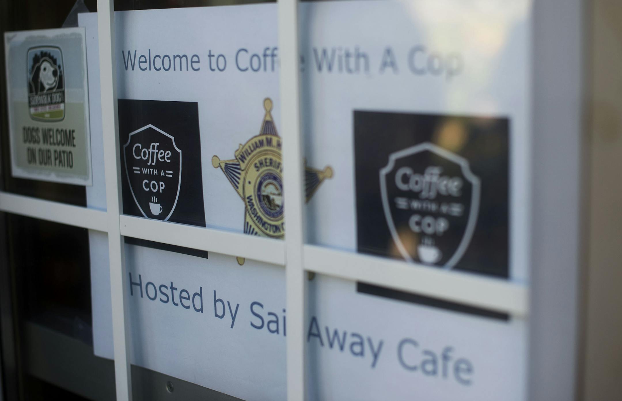 A poster on Sail Away Cafe's door advertised the Coffee With a Cop program in Afton, Minn., on Thursday July 23, 2015. The program intends for cops to meet and connect with law-abiding citizens of Washington County. ] RACHEL WOOLF · rachel.woolf@startribune.com