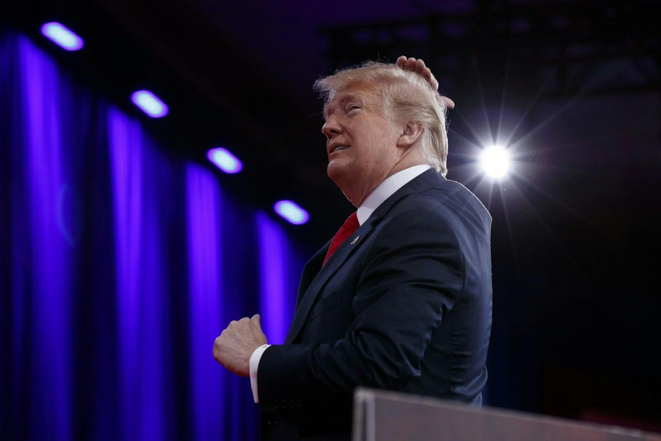 President Donald Trump gestures as he makes a joke about his hair during remarks to the Conservative Political Action Conference, Friday, Feb. 23, 2018, in Oxon Hill, Md.
