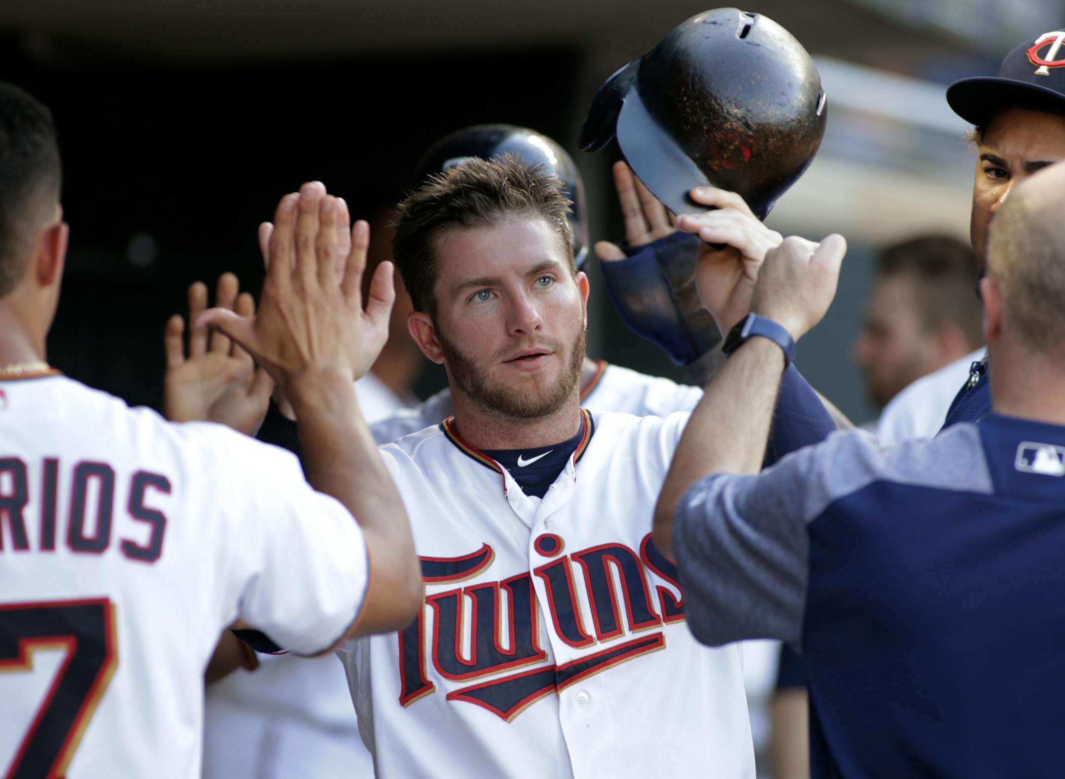 Minnesota Twins' Robbie Grossman is congratulated by teammates after he scored during the third inning of the team's baseball game against the Baltimore Orioles, Thursday, July 6, 2017, in Minneapolis. (AP Photo/Paul Battaglia)
