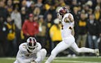 Minnesota Gophers holder Jacob Herbers (47) set up a kick for place kicker Brock Walker (34), who scored a field goal in the final seconds of the seco