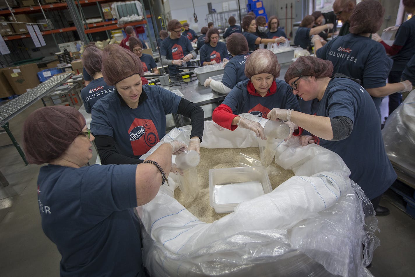 Volunteers from left, Maria Kreidermacher, cq, Sara Grasmon, Muffie Foreman and Erika Finne joined The Current staff to help pack rice at Second Harvest Heartland, Thursday, November 16, 2017 in Golden Valley, MN. ] ELIZABETH FLORES &#xef; liz.flores@startribune.com