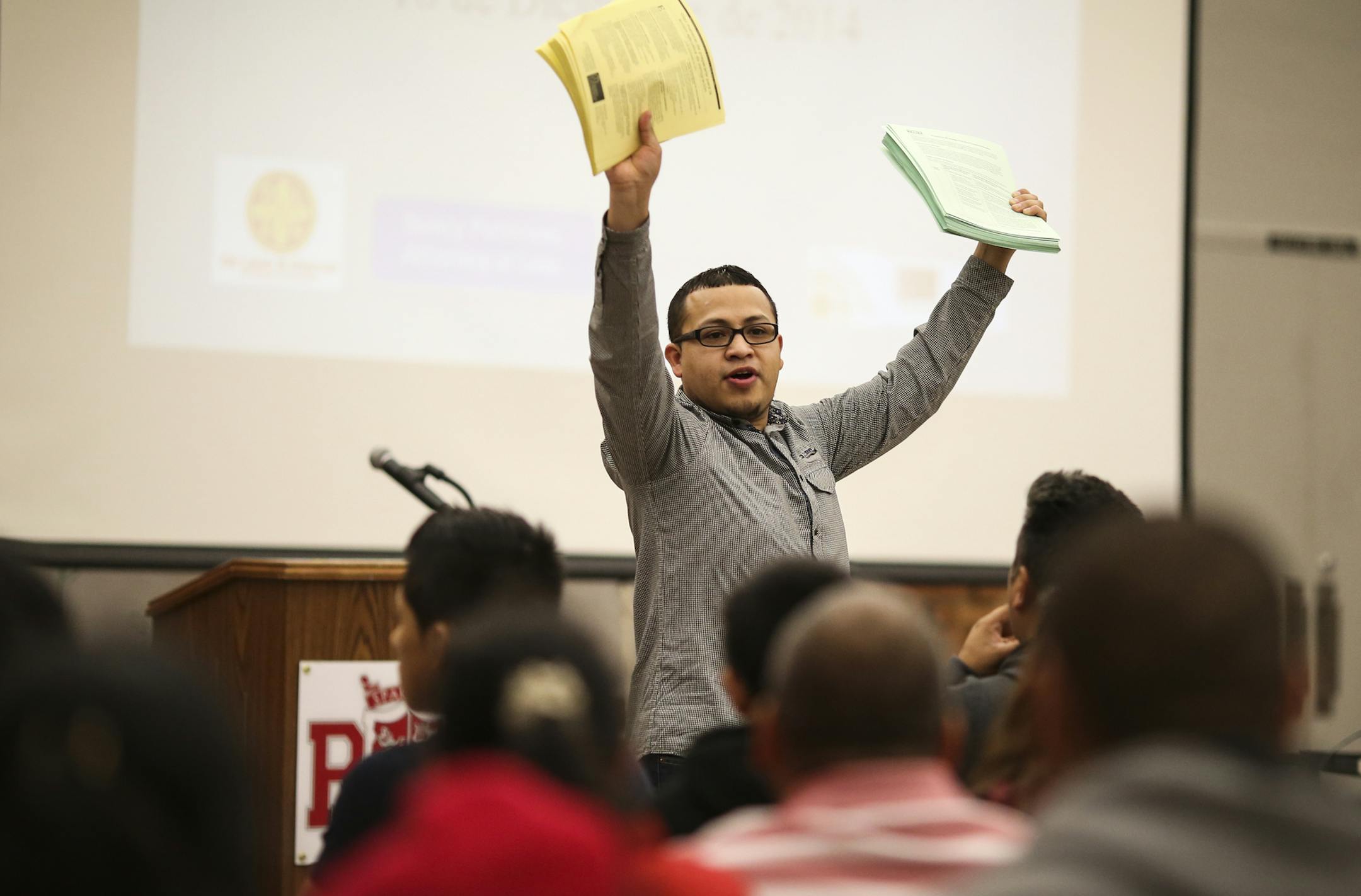 Navigate volunteer Joel Martinez held up informational sheets at a meeting on applying for work permits and deportation relief under Obama's executive order at Richfield High School in Richfield, Minn. on Thursday, December 18, 2014. ] RENÉE JONES SCHNEIDER reneejones@startribune.com