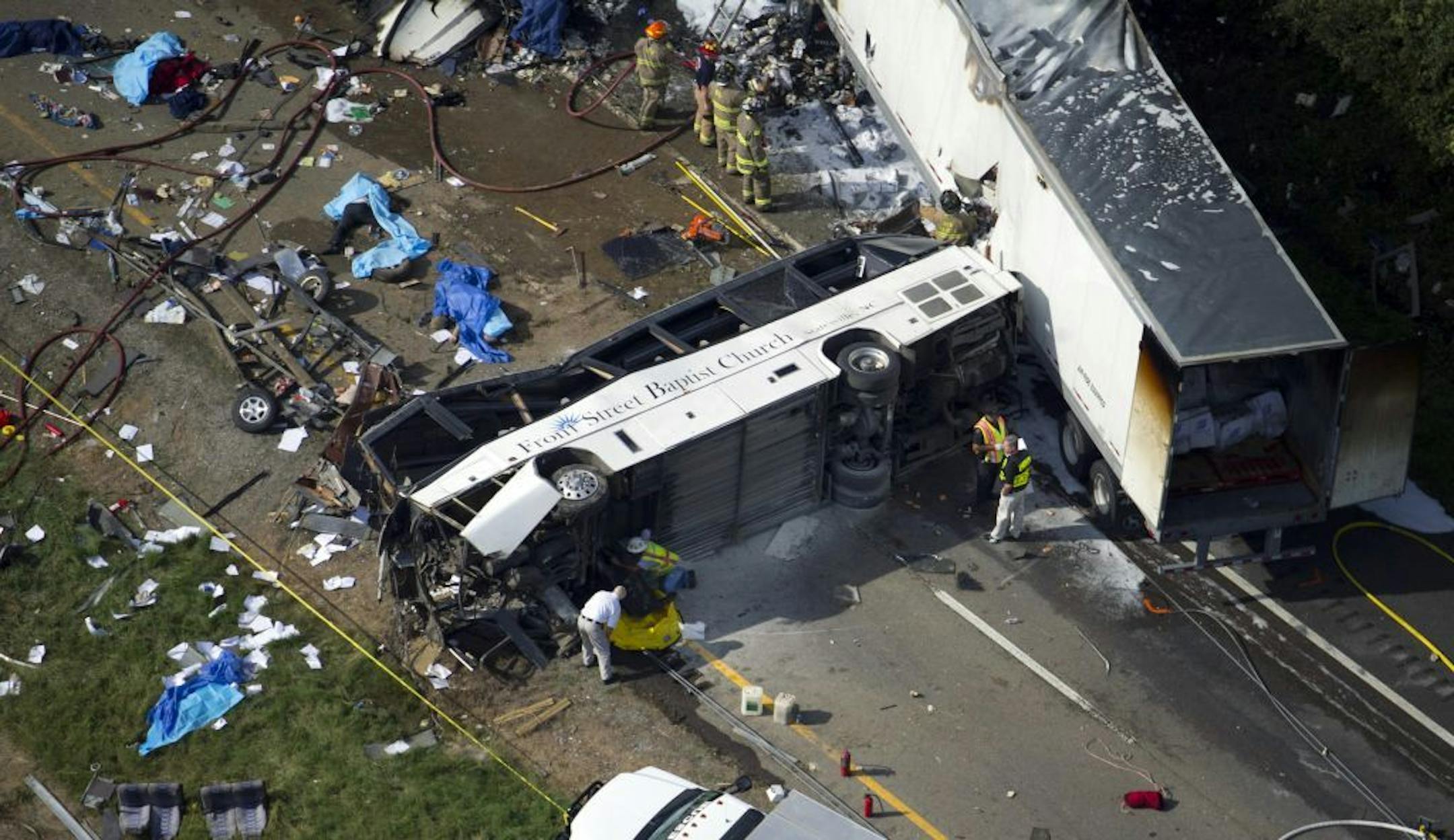 In this aerial photo, emergency workers respond to a crash involving a passenger bus, a tractor-trailer and an SUV near Dandridge, Tenn., on Wednesday, Oct. 2, 2013.