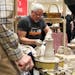 Kevin Caufield, the owner of the Caufield Clay Works in St. Paul, is demonstrating how to do ceramics to Douglas and Ruth Crane.