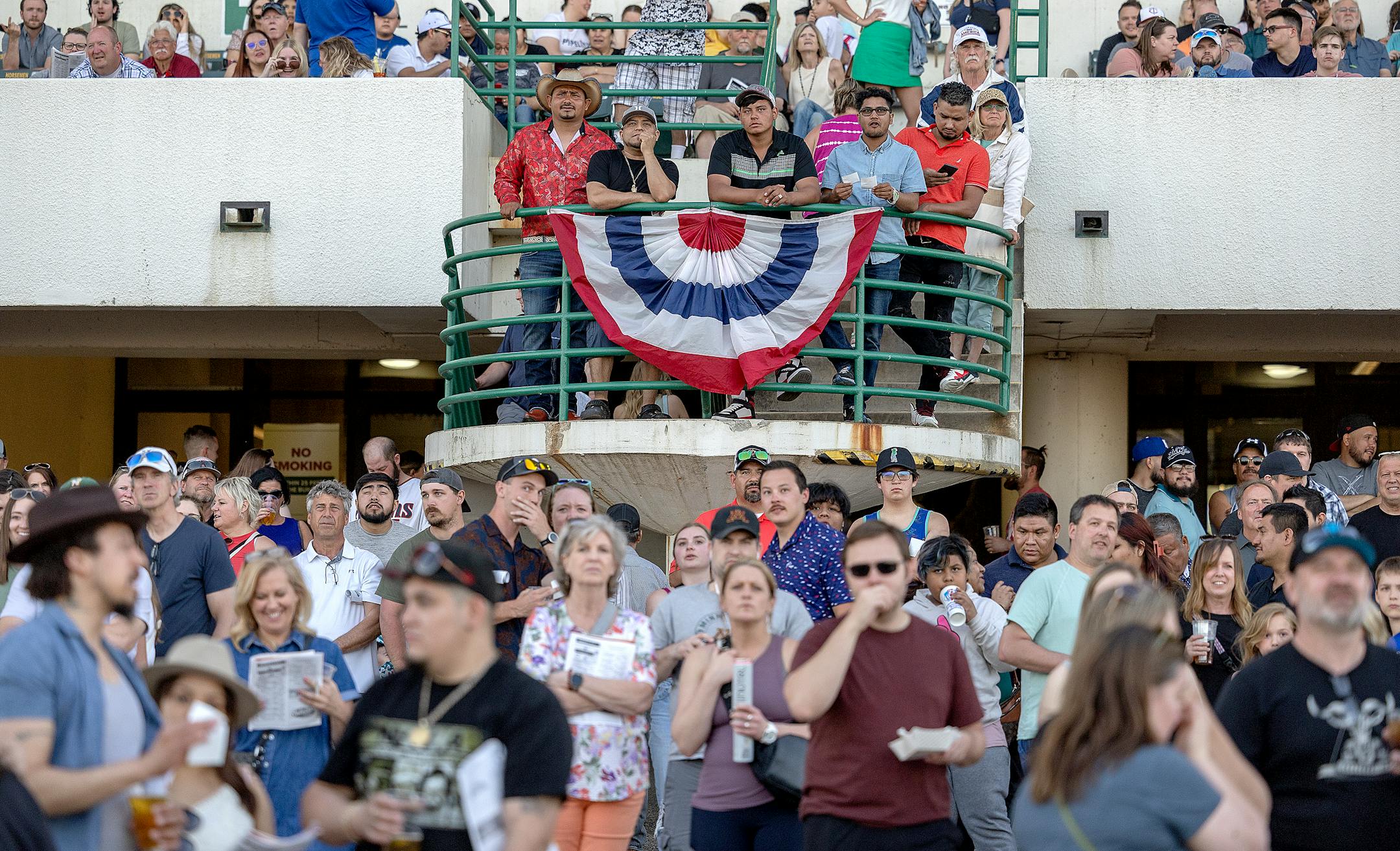 Race fans watch a re-play of a race on opening night at Canterbury Park.