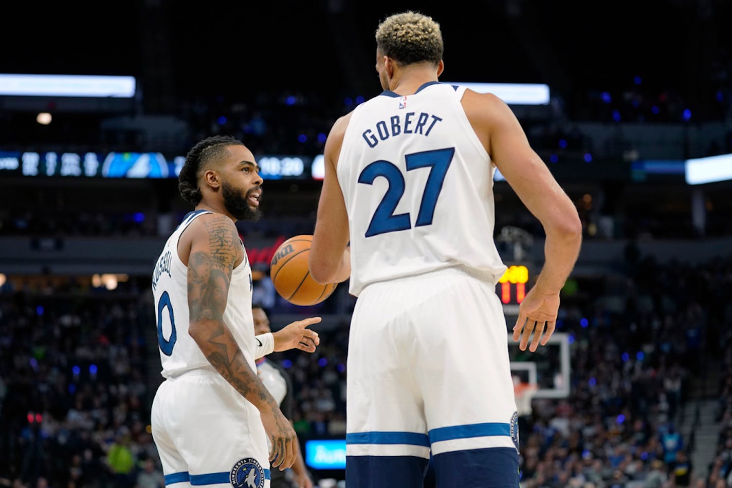 Minnesota Timberwolves guard D'Angelo Russell, left, and center Rudy Gobert talk during the first half of the team's NBA basketball game against the Oklahoma City Thunder, Wednesday, Oct. 19, 2022, in Minneapolis. (AP Photo/Abbie Parr)