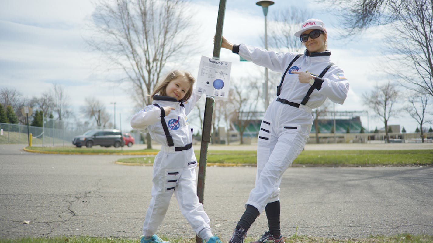 Lilli Prouty with her mom, Julianna, has created a scale model of the solar system that shows the relative distance between the sun and her nine planet in their St. Anthony Park neighborhood of St. Paul.