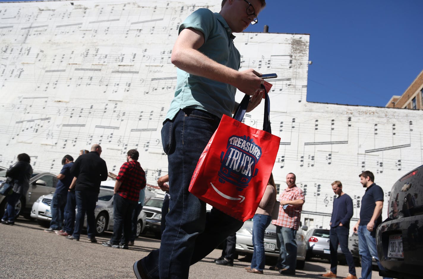 Courtney Lang, top, celebrated the purchase of the Nintendo SNES Classic Edition from an Amazon Treasure Truck, while a customer walked away, above, with his Nintendo product as others waited in line.