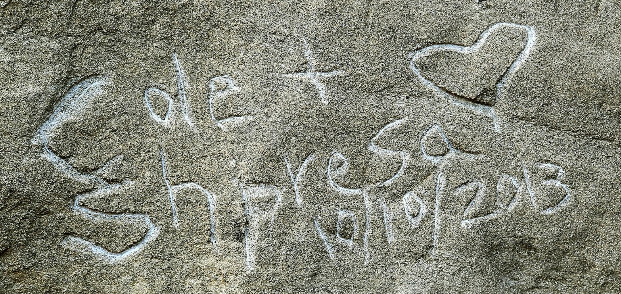 In an Oct.. 31, 2013, photo graffiti spelling "Cole + Shpresa 10/10/2013" is seen carved into the Pompeys Pillar National Monument in Montana.