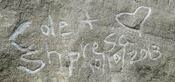 In an Oct.. 31, 2013, photo graffiti spelling "Cole + Shpresa 10/10/2013" is seen carved into the Pompeys Pillar National Monument in Montana.