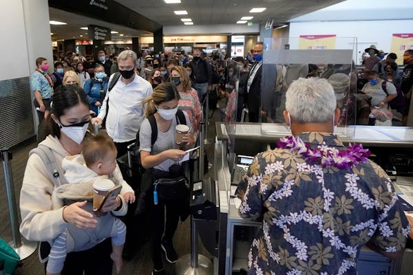 In this Oct. 15, 2020, file photo, United Airlines passengers walk past through the gate to board a flight to Hawaii at San Francisco International Ai