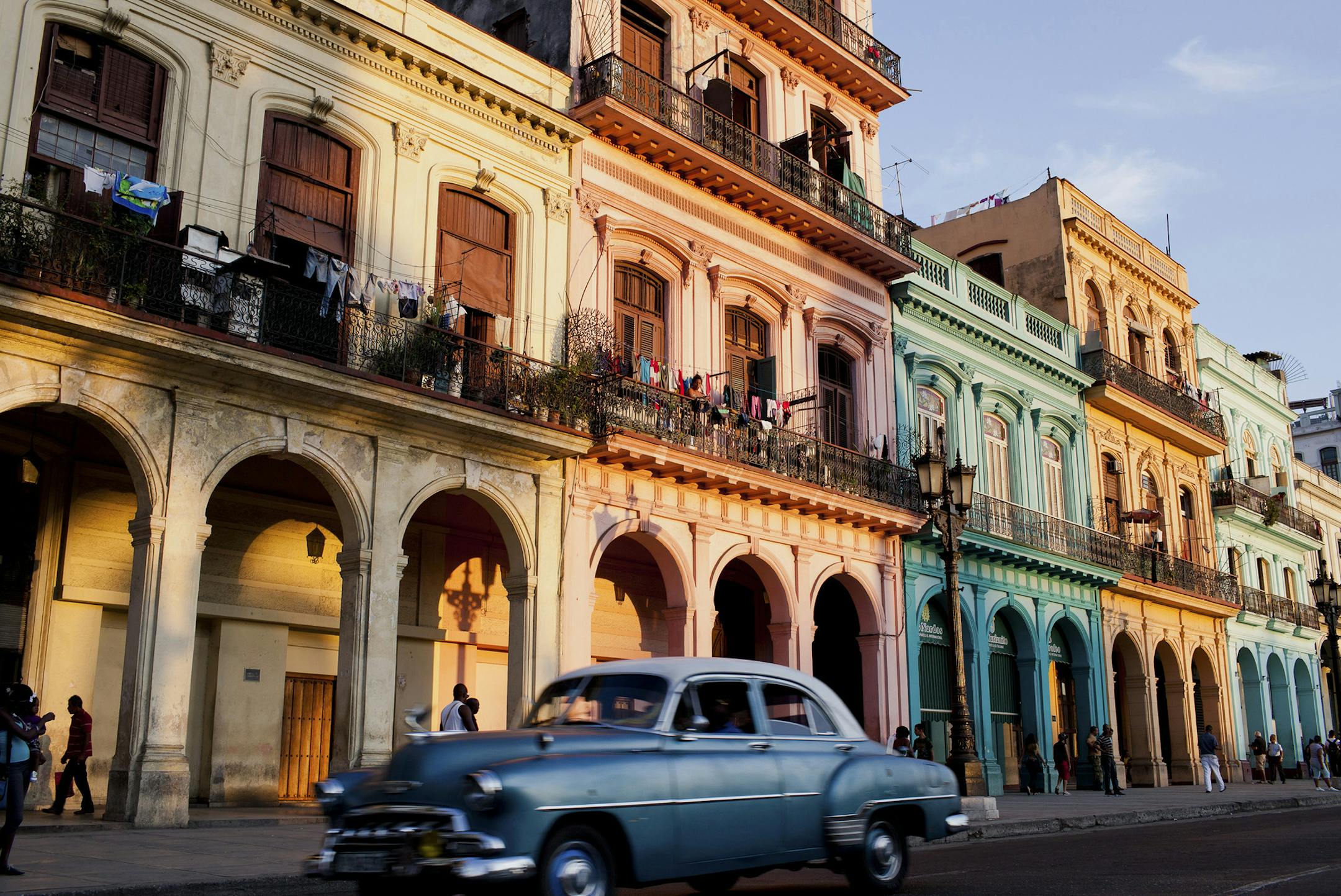A car passes by colorful homes in Havana, part of a restoration project underway, Dec. 21, 2014.
