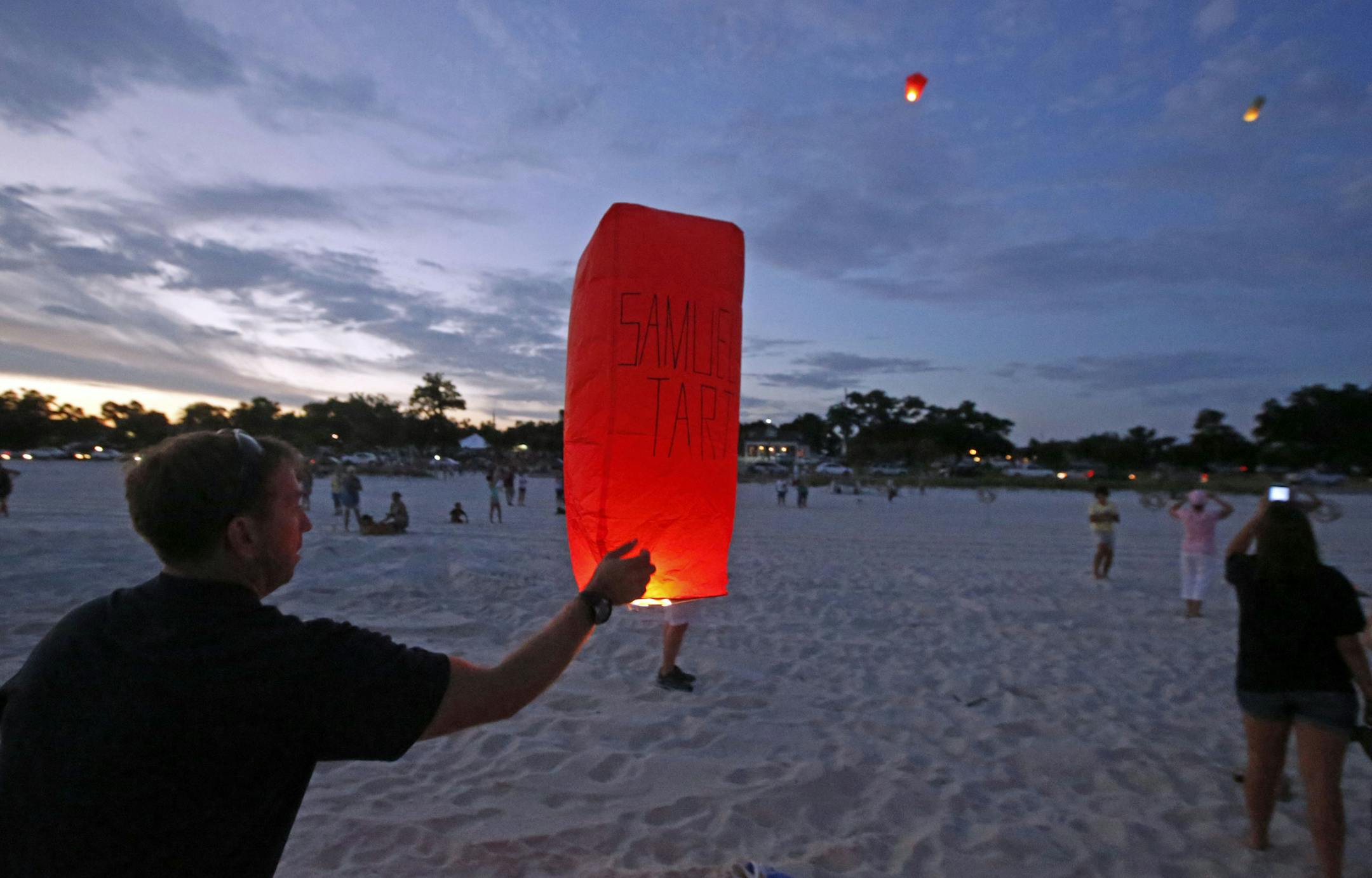 Volunteers light balloons with the names of residents who died during Hurricane Katrina at memorial service on the beach in Pass Christian, Miss., Saturday, Aug. 29, 2015. Residents and public officials joined in the 10th anniversary commemoration of those residents who died at memorial services and remembrances throughout the Gulf Coast. (AP Photo/Rogelio V. Solis)