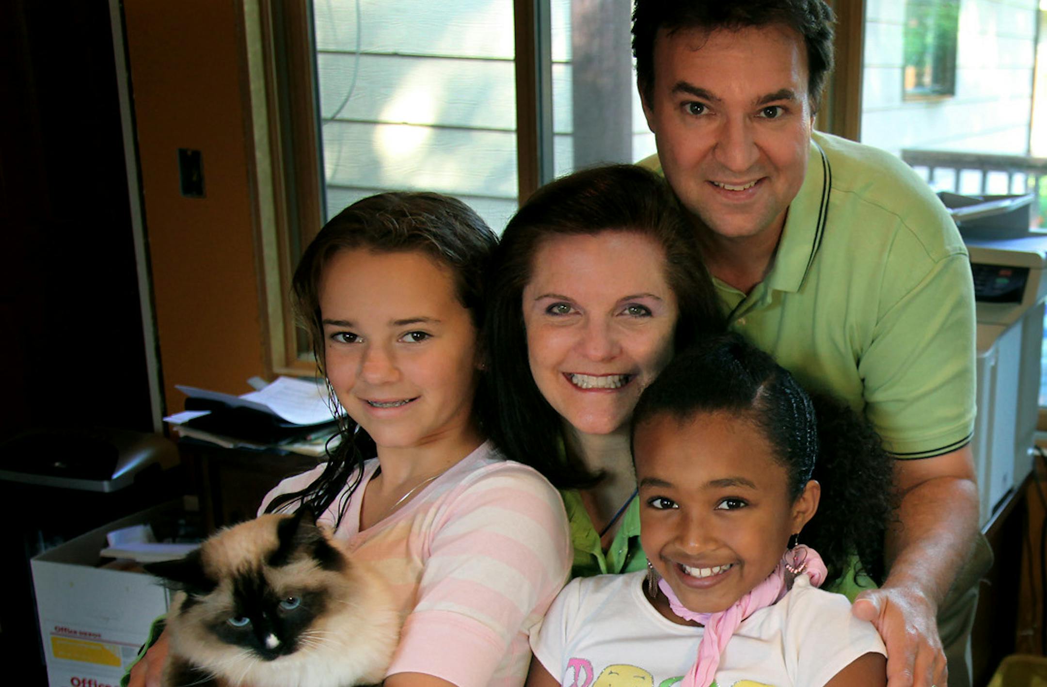 ELIZABETH FLORES • eflores@startribune.com July 31, 2009 - Shoreview, MN - Radio personality Toni Schutta was surrounded by her family including daughters Taylor Sislo-Schutta, 13, left, with their cat "Lily" and Brianna Sislo-Schutta, 9, and husband Kevin Sislo. Schutta is the host of a local new internet radio program known as "www.voiceamerica.com, "real parents, real solutions." She hosts the program from her home computer.