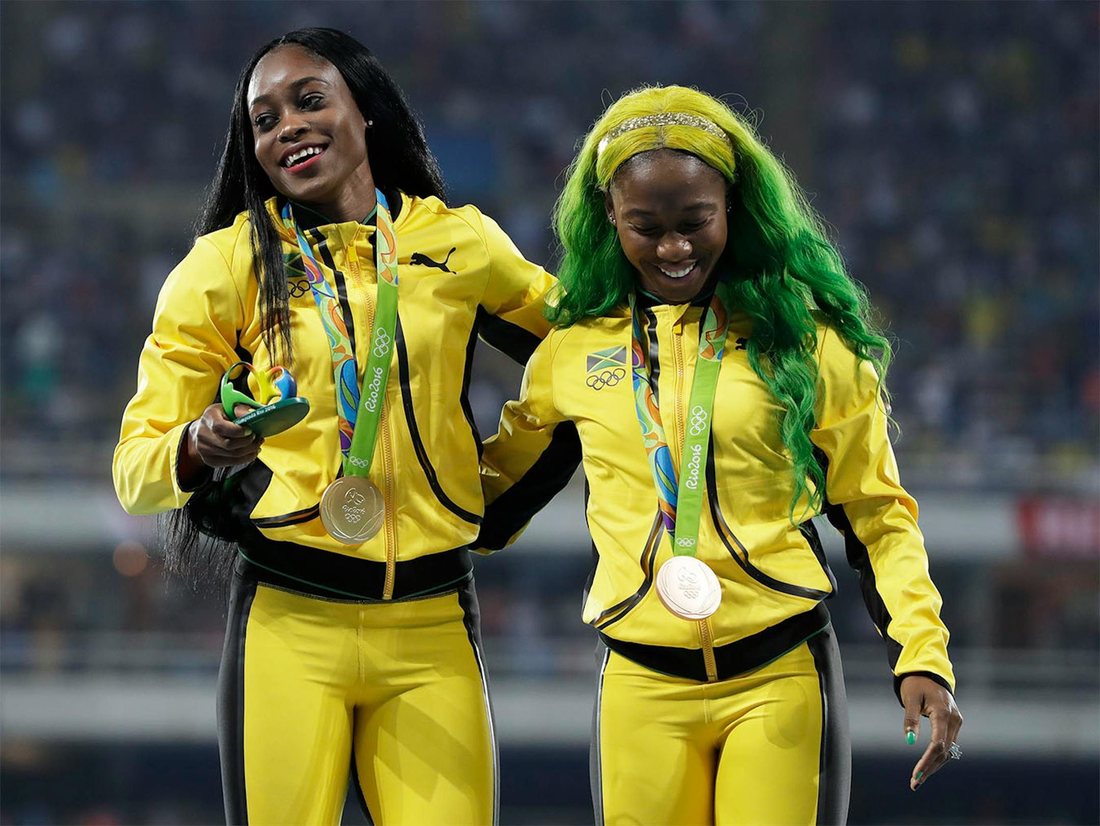 Gold medallist Jamaica's Elaine Thompson, left, and compatriot and and bronze medallist Shelly-Ann Fraser-Pryce celebrate their medals for the women's 100-meter final during the athletics competitions of the 2016 Summer Olympics at the Olympic stadium in Rio de Janeiro, Brazil, Sunday, Aug. 14, 2016.