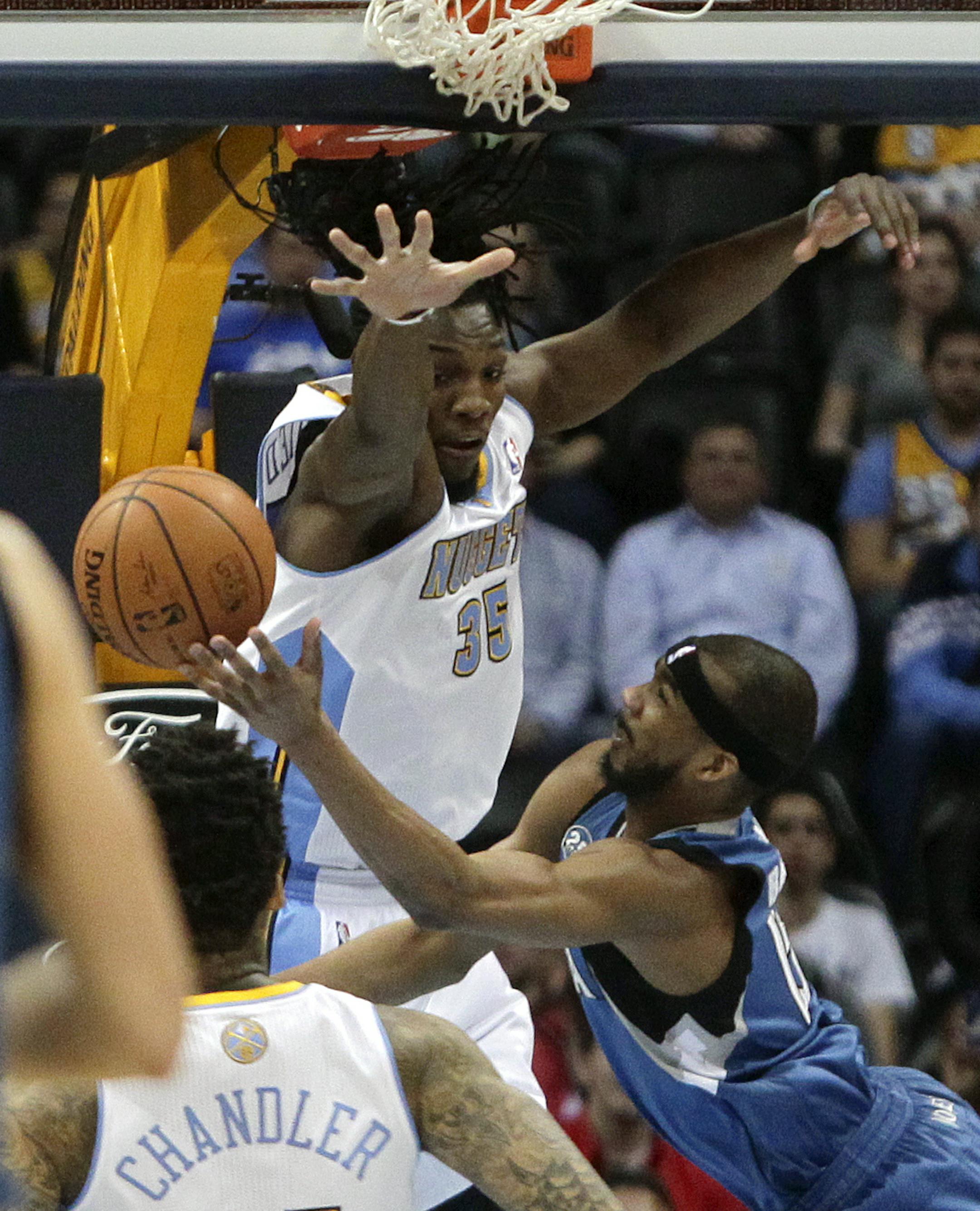 Minnesota Timberwolves' Corey Brewer, bottom tries to shoot around Denver Nuggets' Kenneth Faried during the first quarter of an NBA basketball game Monday, March 3, 2014, in Denver. (AP Photo/Barry Gutierrez)