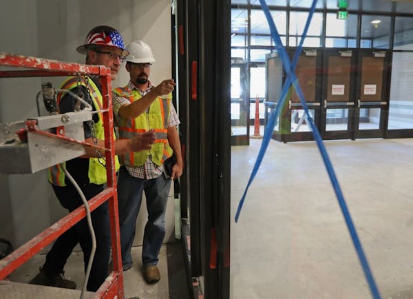 Rick Mickschl (left) and Isaac Stensland walked through and inspected an addition being constructed onto Humbolt High School in St. Paul.