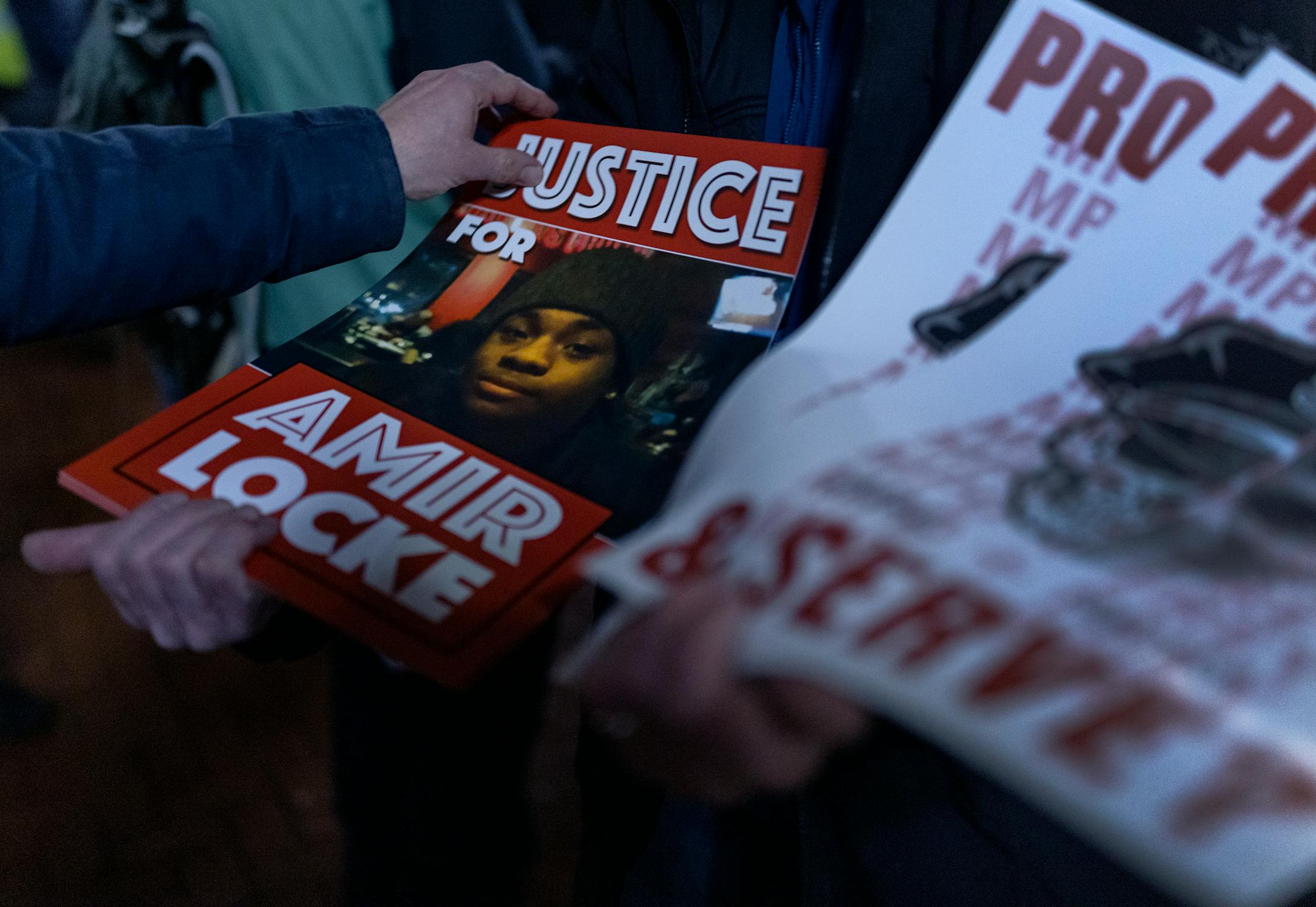 Signs are distributed during the National Solidarity Justice for Amir Locke march.