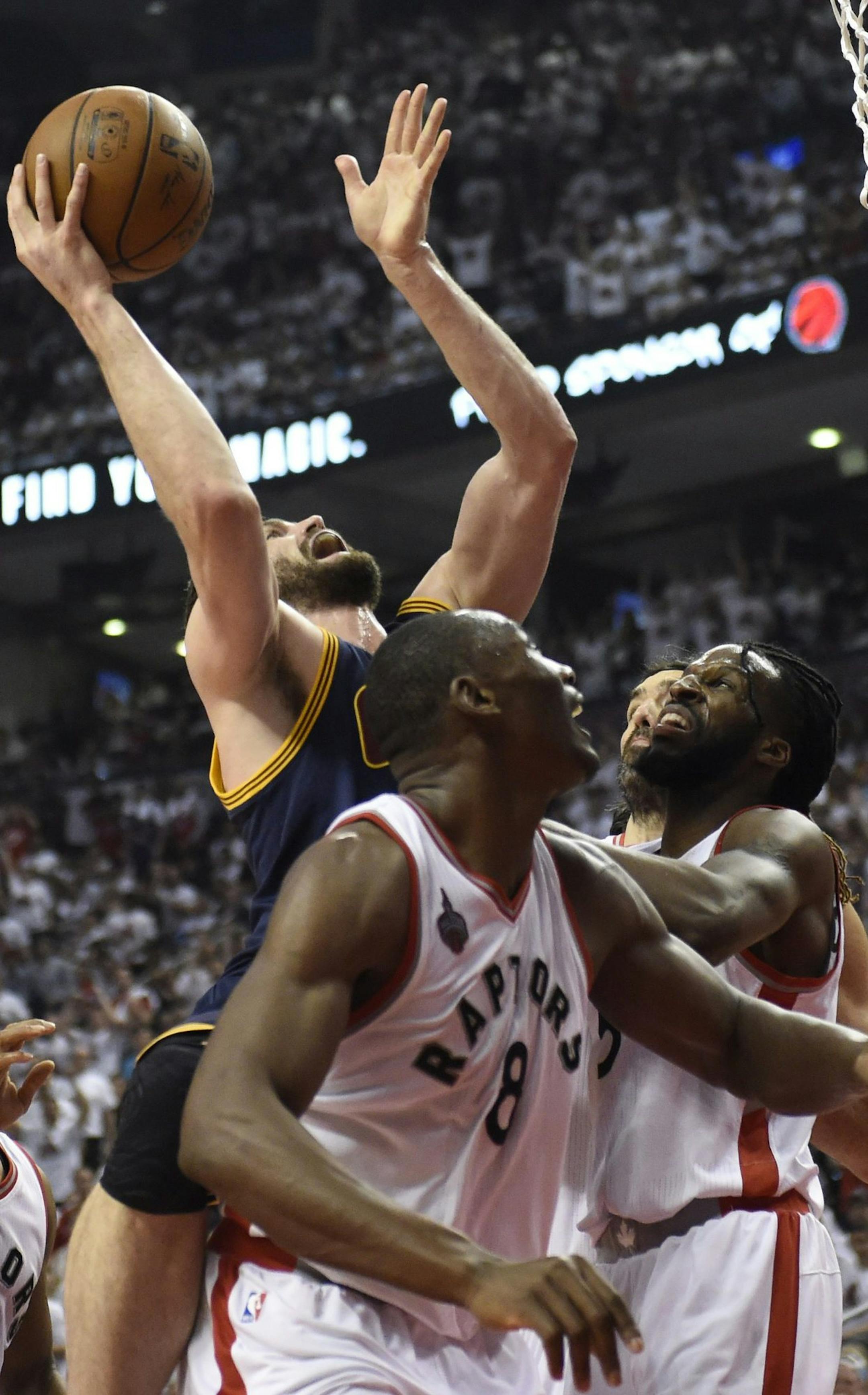 Cleveland Cavaliers forward Kevin Love is stopped from making it to the basket by Toronto Raptors centre-forward Bismack Biyombo (8), DeMarre Carroll and Luis Scola during second half Eastern Conference final playoff basketball action in Toronto on Monday, May 23, 2016. (Frank Gunn/The Canadian Press via AP) MANDATORY CREDIT