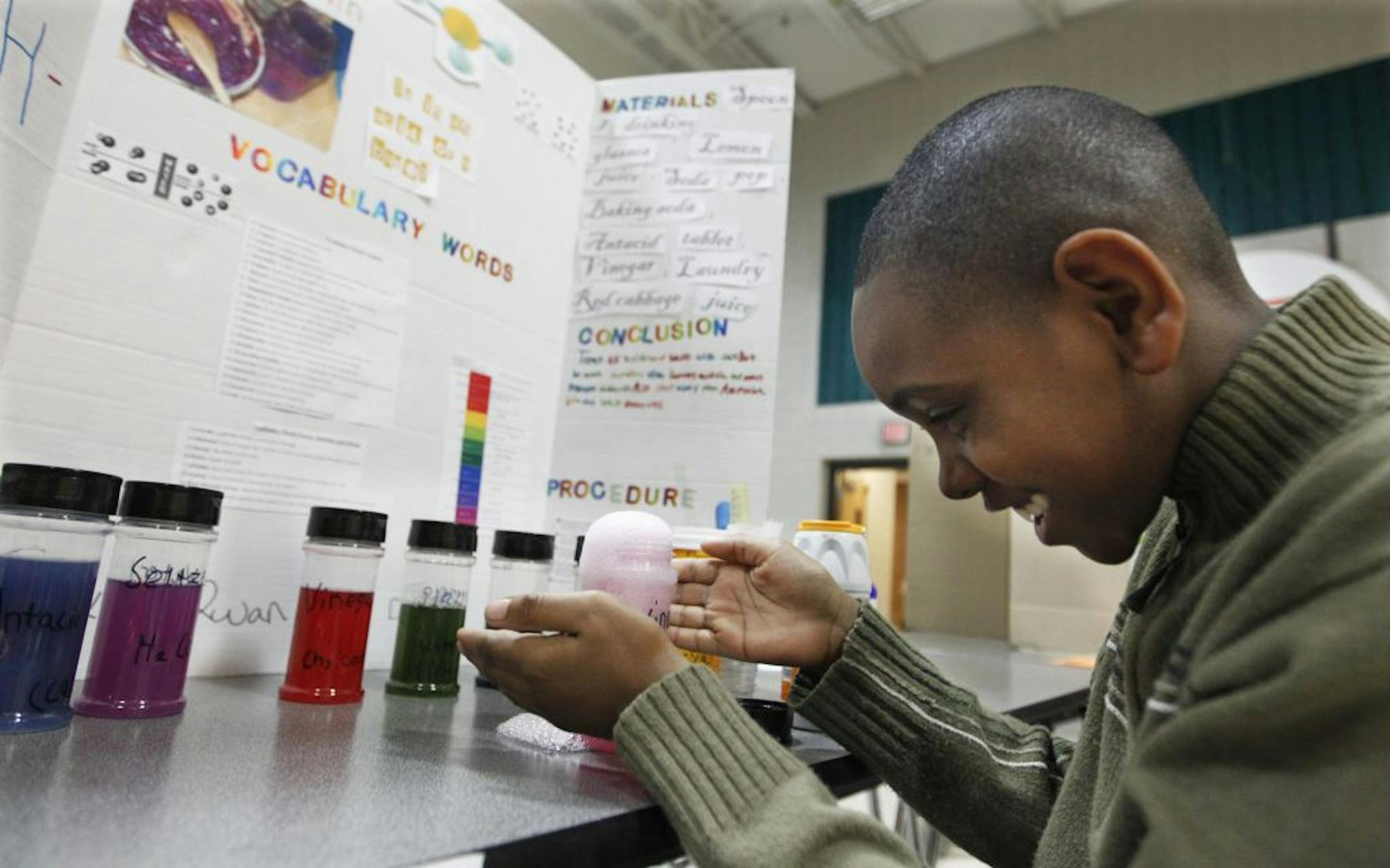Harambee Elementary student DJ Bryant, 10, watched with glee as the vinegar overflowed when he added some baking soda to neutralize it during his demonstration about acidity. His project was part of the school's science fair.