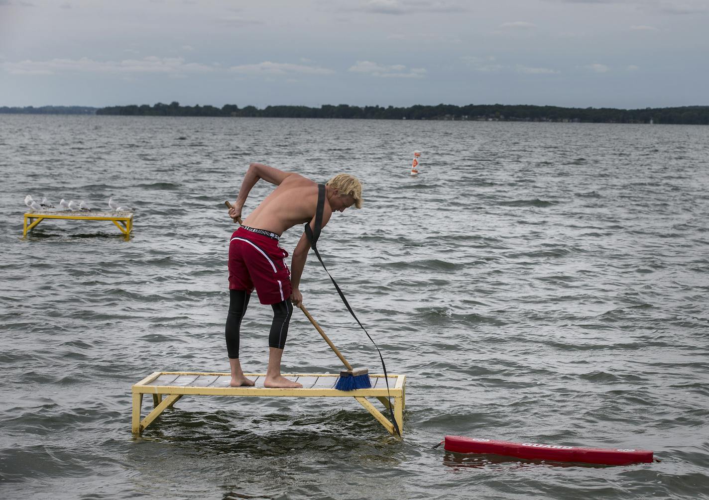 Lifeguard Jaeger Jergenson, 15, cleans the pedestals in the swimming area on the empty Glenwood City Beach on Lake Minnewaska in Glenwood on Wednesday, July 8, 2015. ] LEILA NAVIDI leila.navidi@startribune.com /