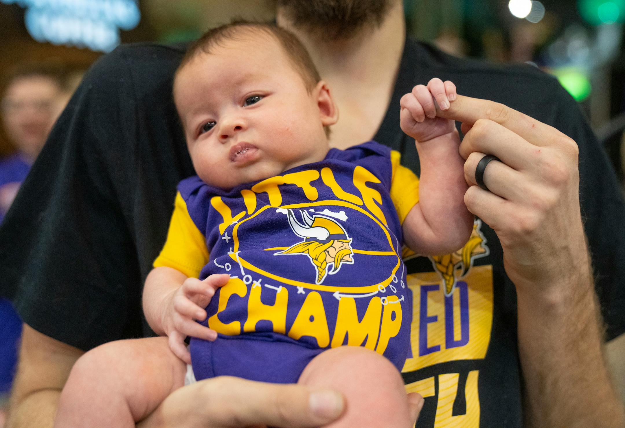 Hunter Olson, 6 weeks, is held by his father, Chris, to watch the Minnesota Vikings cheerleaders perform.