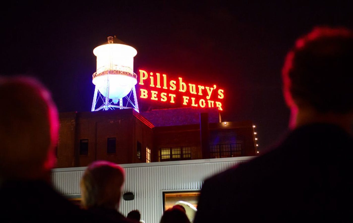 People cheered and applauded from the rooftop terrace of the A Mill Artist Lofts as the Pillsbury sign was relit Monday, Nov. 2, 2015, in Minneapolis.