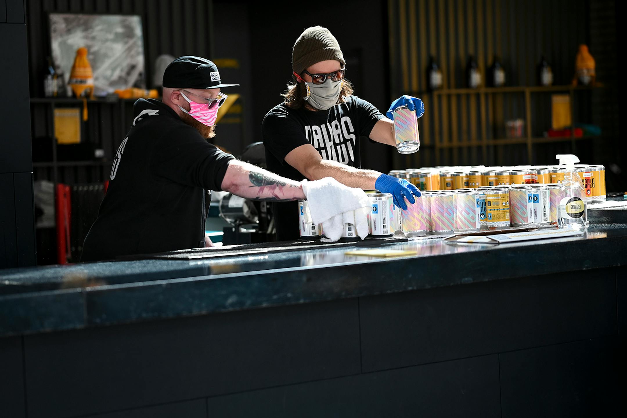 Bauhaus Brew Labs co-owner Mark Schwandt, left, and brewer Dan Larsen dried off crowlers while fulfilling pick up orders Friday afternoon. Despite strong sales of wine, spirits and beer in liquor stores since COVID-19 hit, craft breweries in Minnesota and other states have taken a body blow, especially the smaller breweries that produce less than 1,000 barrels annually.