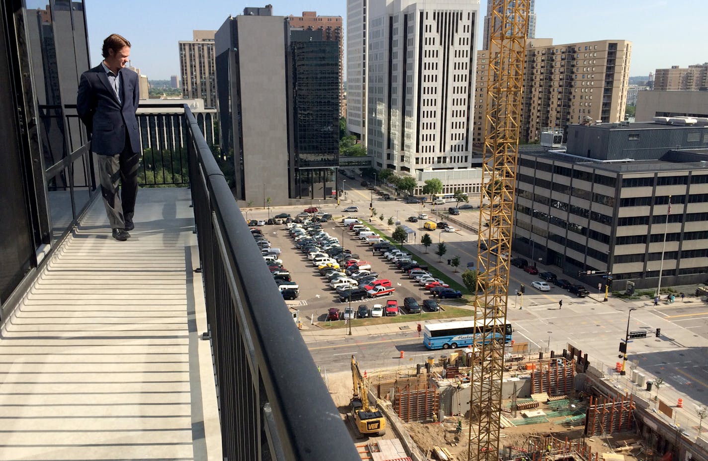 Nick Murnane, real estate manager for Opus Development Co., is standing on the balcony at the new Nic on Fifth apartments where he has a view an apartment building being developed by a competing developer. Just beyond that site is the Ritz block, now a parking lot but slated to become more apartments.