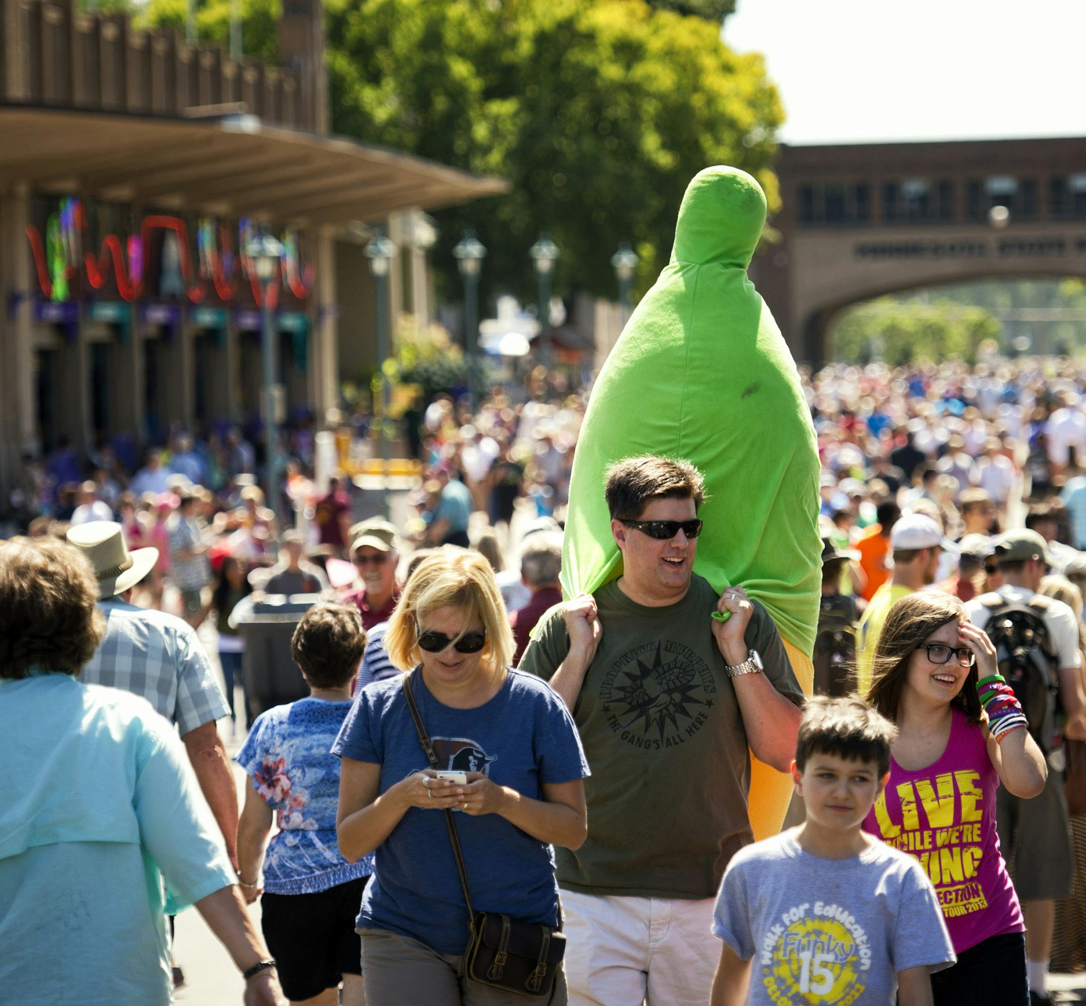 Kevin Schemery entertained his 13-year-old daughter Alex with corny corn puns after Alex's grandpa won this huge stuffed ear of corn by tipping a bottle upright with a ring fishing pole. The first day of the Minnesota Fair, Thursday, August 22, 2013 ] GLEN STUBBE * gstubbe@startribune.com