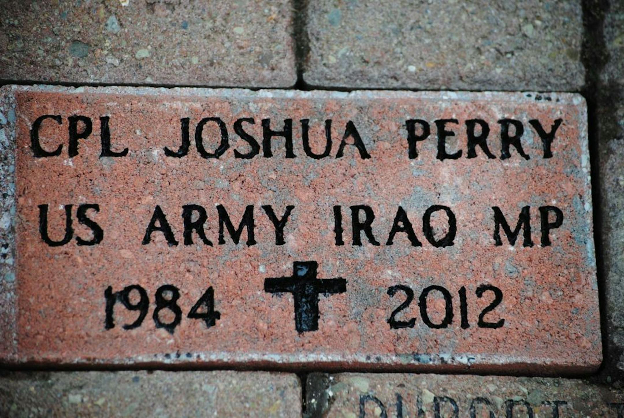 Army Corporal Joshua Perry's memorial brick is the newest addition to the Soldiers and Veterans Brick Line, placed on Saturday, March 3, 2013, at the Plaza of the Sayre Movie Theatre, in Sayre, Pa. Family members, friends, veterans and community members came out to watch the brick placement on the one-year anniversary of Cpl. Joshua Perry's death. Perry lost his battle with Post Traumatic Stress Disorder a year ago after tours as an MP in Korea and Iraq.