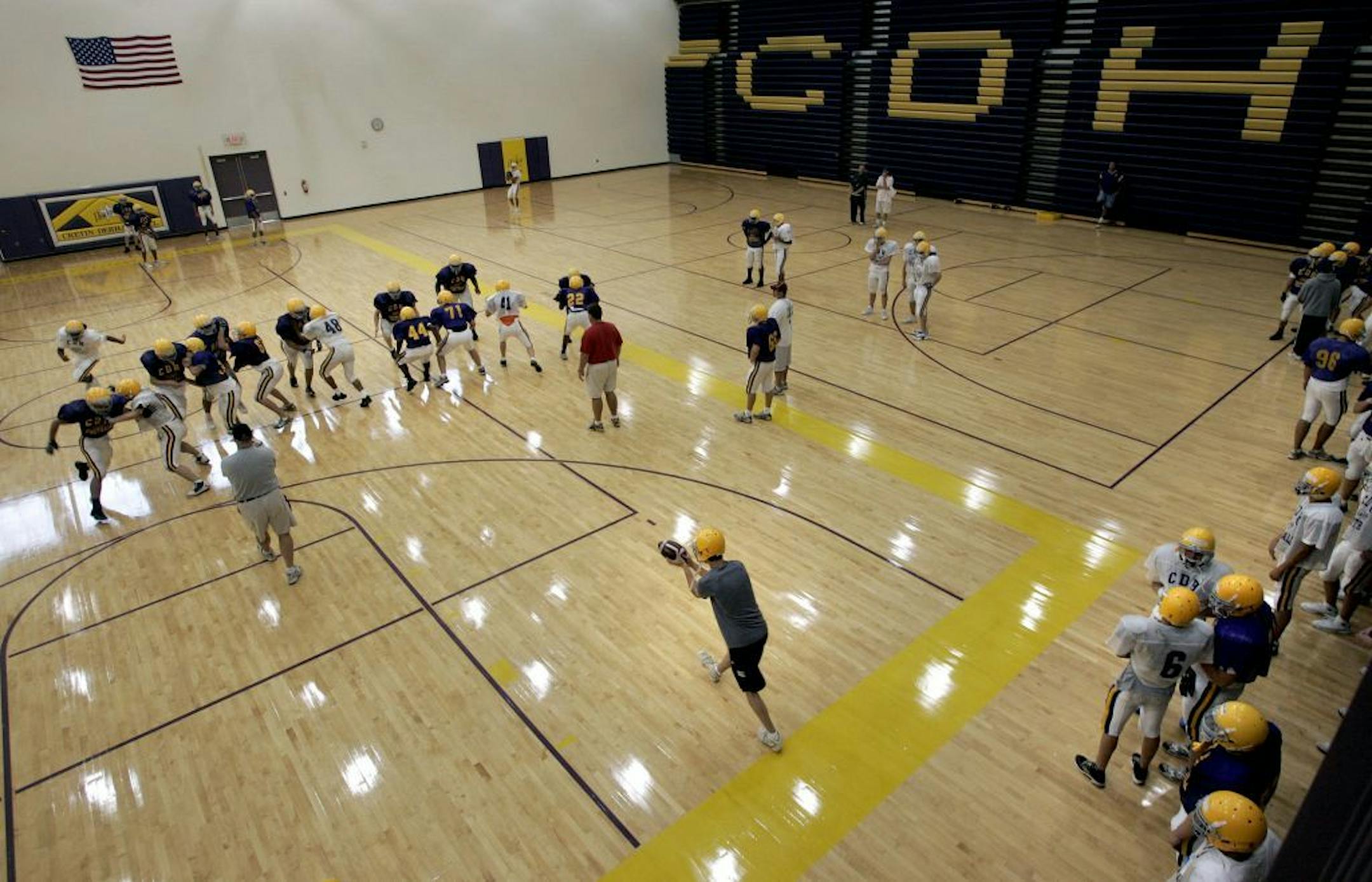 ELIZABETH FLORES � eflores@startribune.com August 23, 2007 - St. Paul, MN - Cretin-Durham Hall football players practice plays during pre-season practice in the high school's gym.