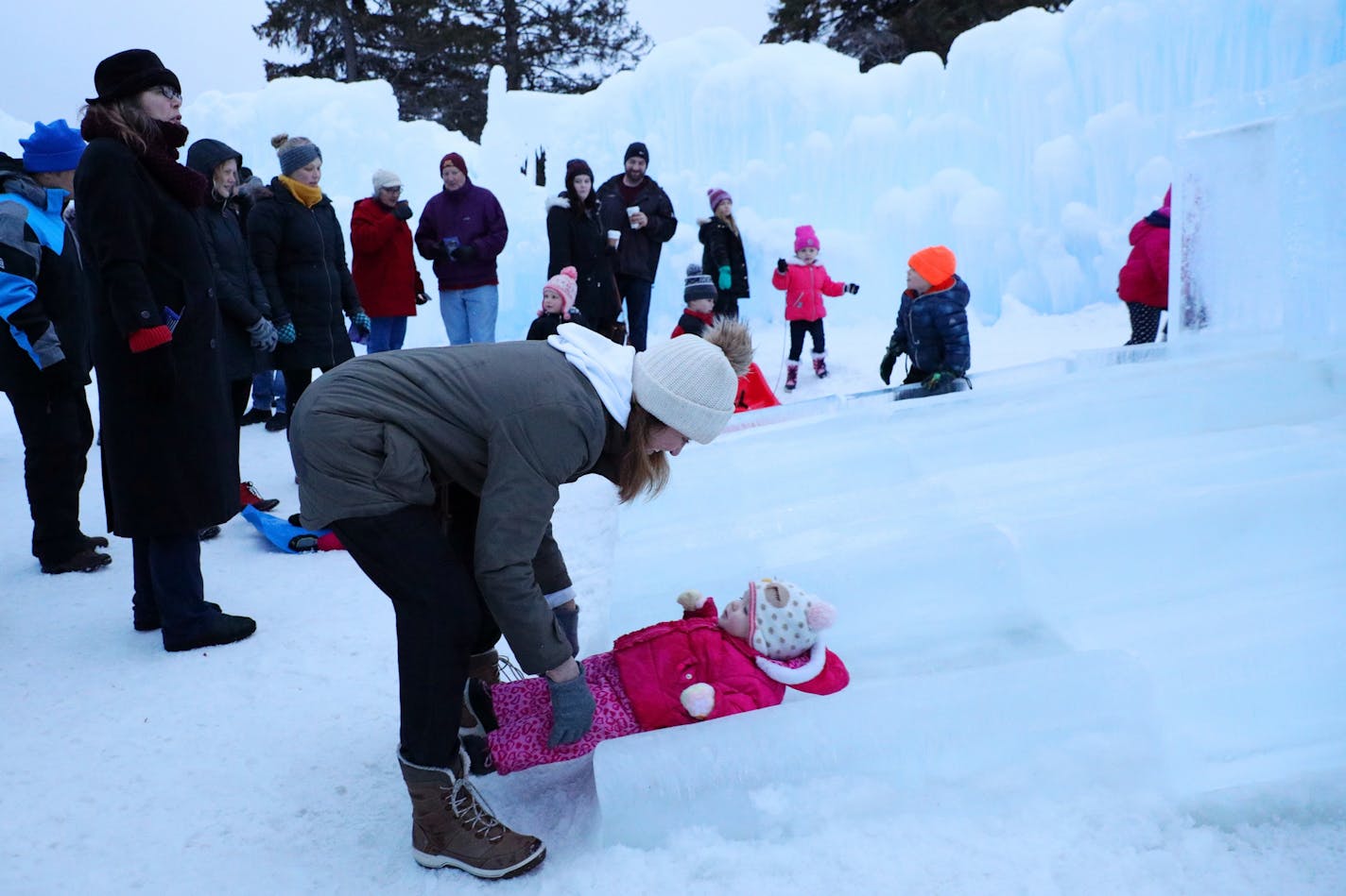 Jody Lammer caught her daughter Eva Hellquist, 1, as she went down an ice slide bundled up Wednesday evening at the Stillwater Ice Castle.