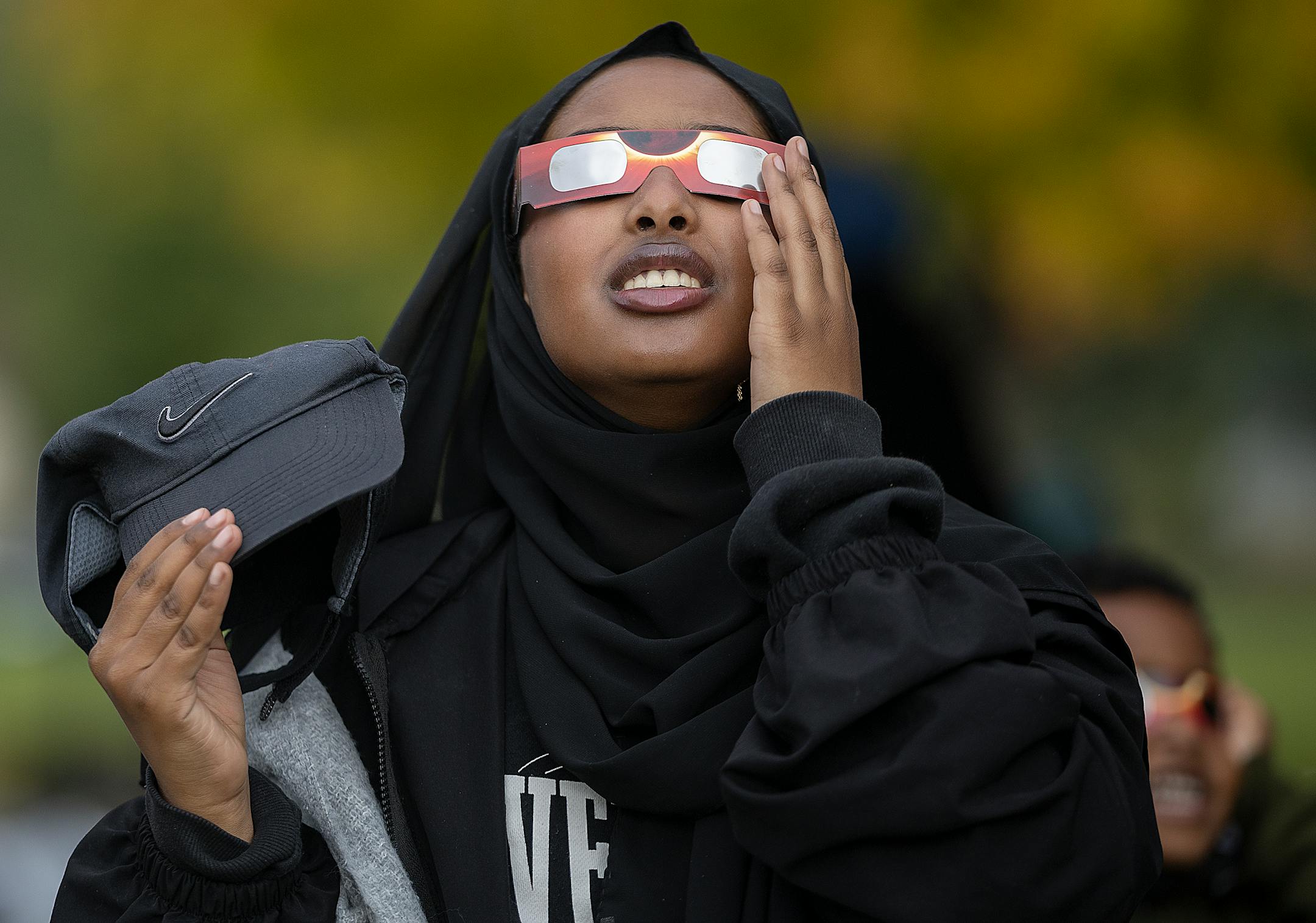 Tasnim Husein, cq, views the annular Eclipse during a viewing party at Commons Park in Fridley, Minn., on Saturday, Oct. 14, 2023.
