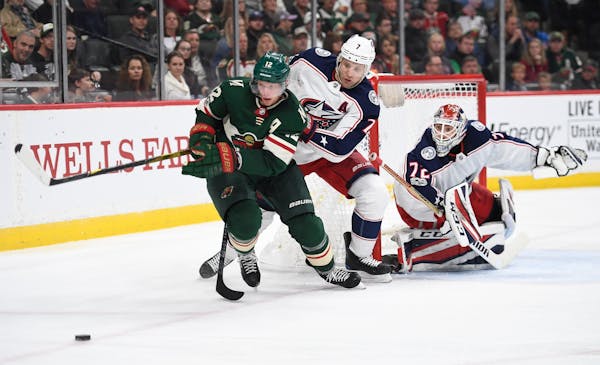Minnesota Wild center Eric Staal (12) tried to control a rebounded shot while being challenged from behind by Columbus Blue Jackets defenseman Jack Jo