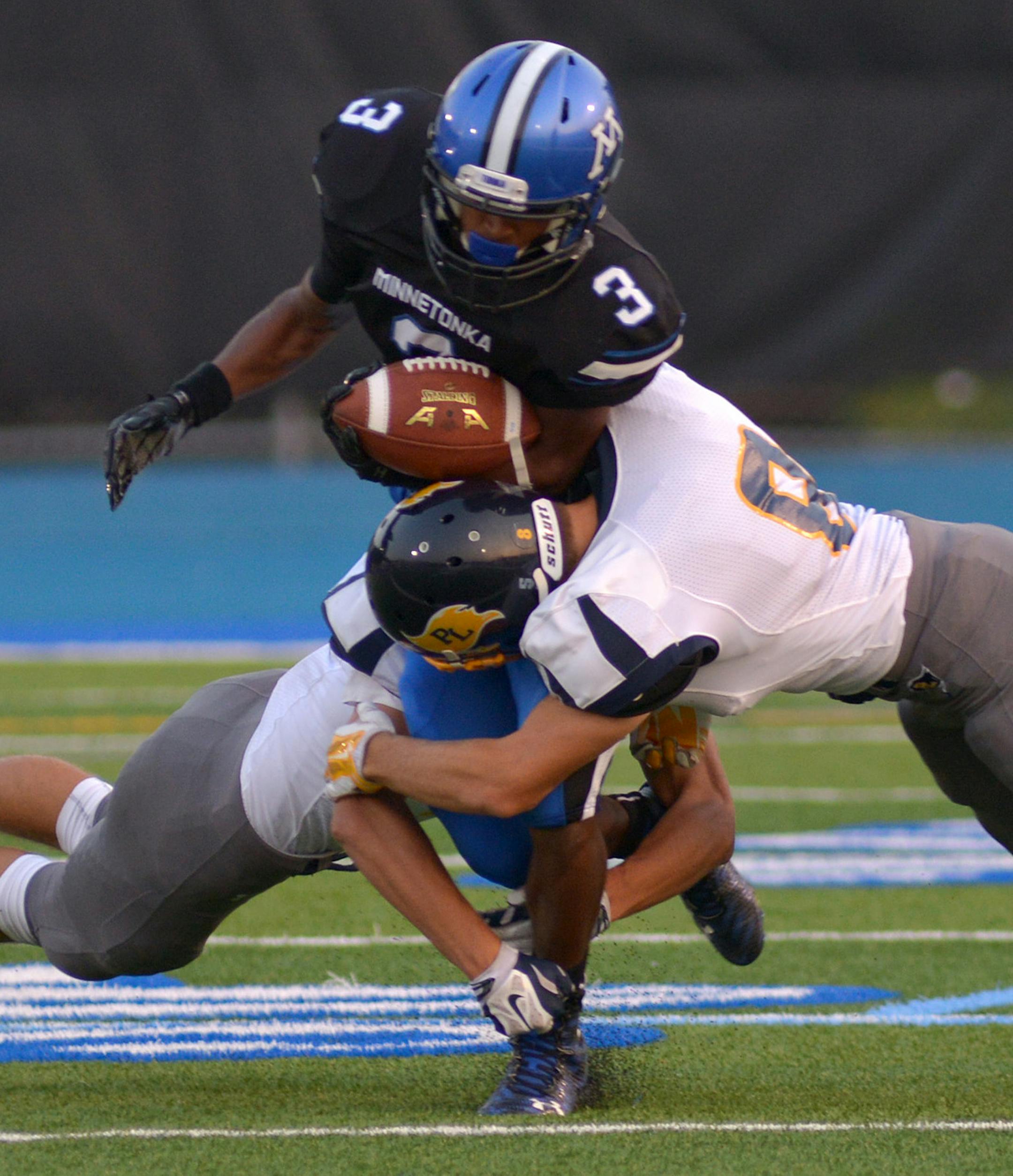 Prior Lake defense tackles Minnetonka senior Amar Millerduring the first half of the regular season game Friday night at Minnetonka High School. Prior Lake led Minnetonka 31-0 at halftime. ] (SPECIAL TO THE STAR TRIBUNE/BRE McGEE) **Amar Miller (Minnetonka, black, 3)