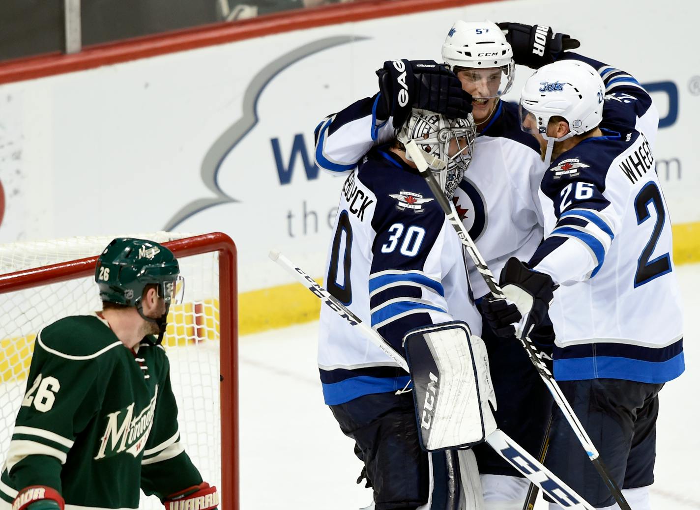 Minnesota Wild left wing Thomas Vanek (26), left, of Austria, watches as Winnipeg Jets goalie Connor Hellebuyck (30), defenseman Tyler Myers (57) and right wing Blake Wheeler (26) celebrate their win in an NHL hockey game Friday, Jan. 15, 2016, in St. Paul, Minn. The Jets won 1-0. (AP Photo/Hannah Foslien)