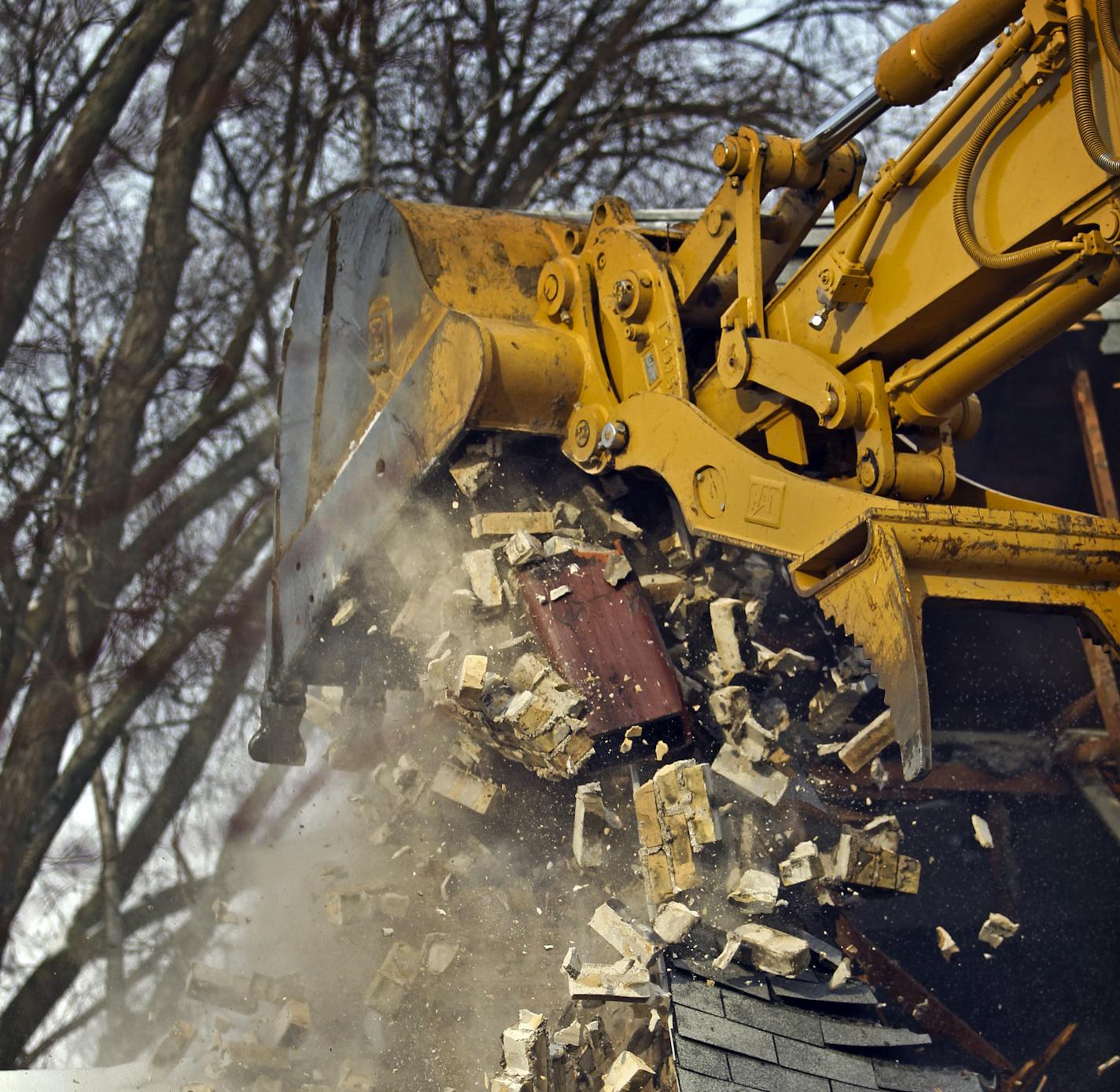 A backhoe operator from Final Grade worked on knocking down a chimney on a cape cod home Thursday, Feb. 23, 2012, in Edina, MN, in order to build a new home on the lot for a family moving to Edina from Seattle.] DAVID JOLES*djoles@startribune.com - A cape cod home was torn down in the 5300 block of Kellog Ave. Thursday in Edina, which had a record number of tear downs in 2011 and is on pace to break that record.