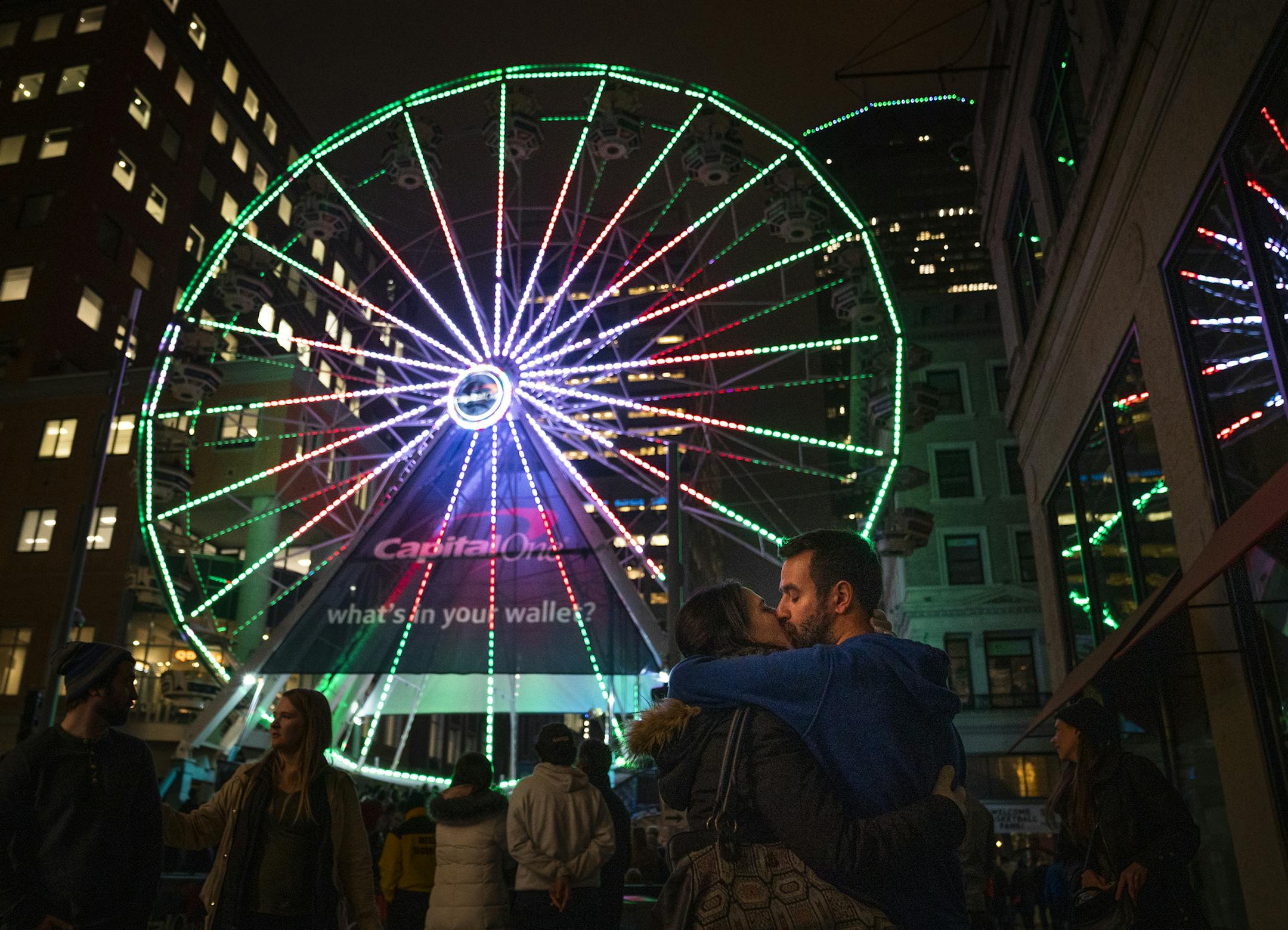 Carlos Abril and Almudena Andres, both visiting from Spain, share a kiss in front of the ferris wheel on Nicollet Mall during Tip-Off Tailgate. ] LEILA NAVIDI &#xa5; leila.navidi@startribune.com BACKGROUND INFORMATION: Final Four fan gather at the Tip-Off Tailgate at Nicollet Mall in Minneapolis on Friday, April 5, 2019.