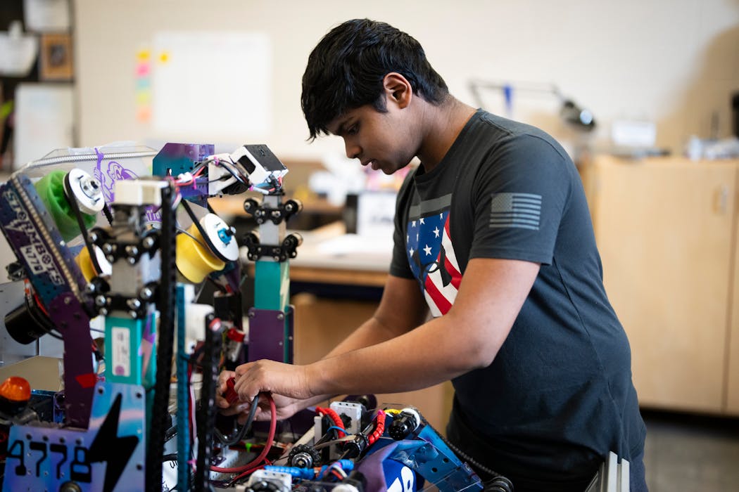 Mahi Madhan Kumar, 16, tinkers with a robot his robotics team made at Chanhassen High School on Tuesday.