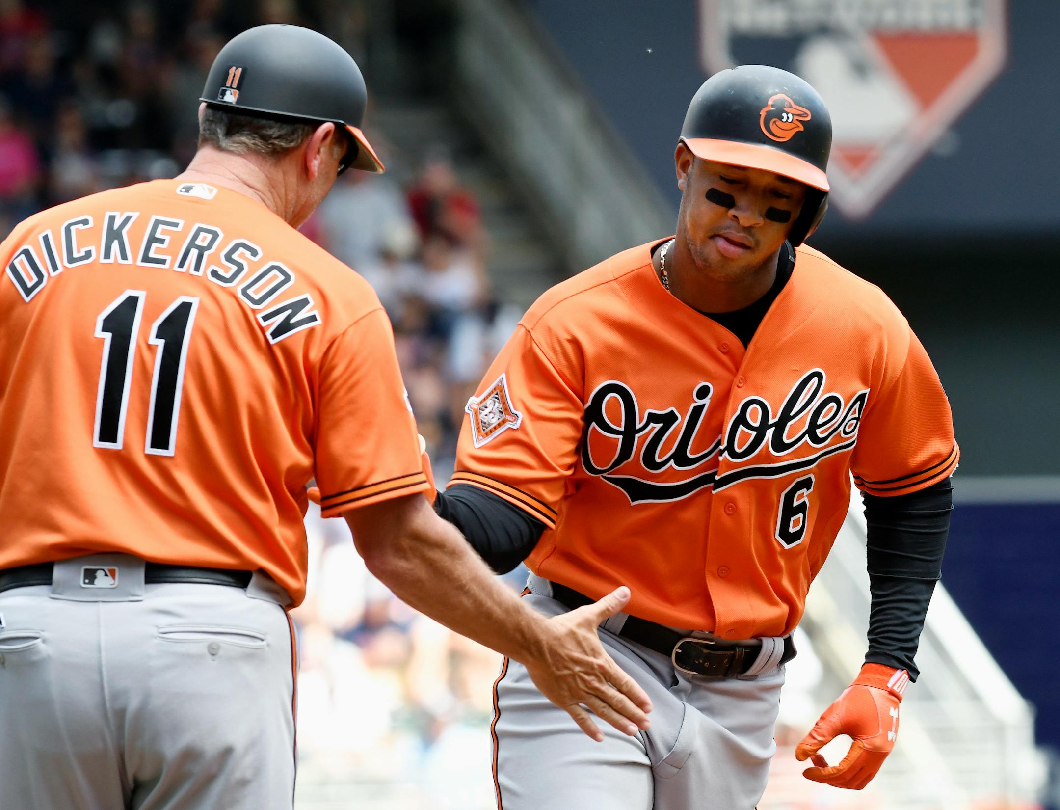 Baltimore Orioles third base coach Bobby Dickerson (11) congratulates the Orioles' Jonathan Schoop, right, as he rounds third with a two-run home run in the fourth inning of a baseball game, Saturday, July 8, 2017, in Minneapolis. (AP Photo/Tom Olmscheid)