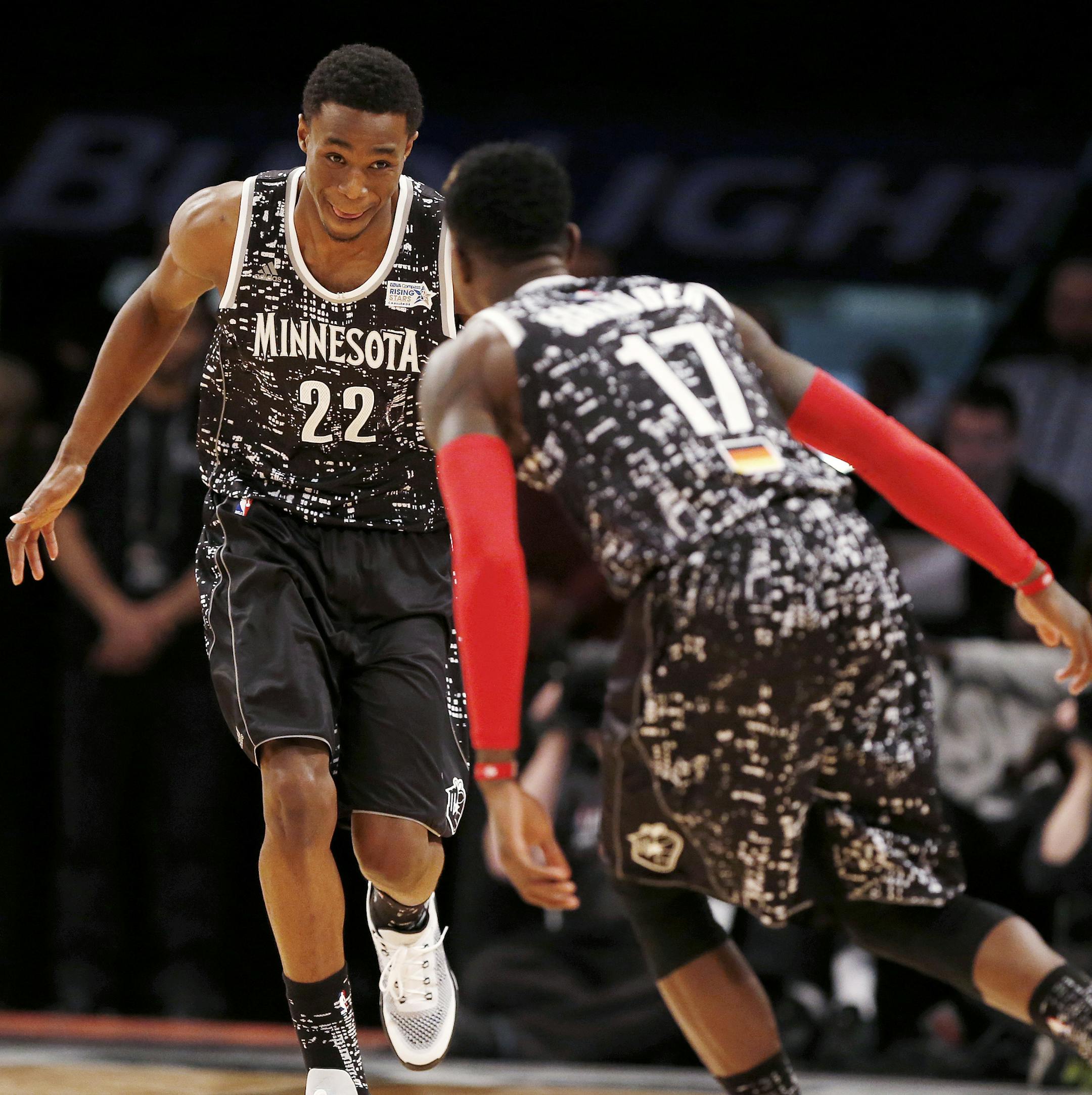 World Team's Andrew Wiggins, left, of the Minnesota Timberwolves, and Dennis Schroder, of the Atlanta Hawks, celebrate after Schroder assisted Wiggins on a basket during the first half of the Rising Stars NBA All-Star Challenge against the U.S. Team, Friday, Feb. 13, 2015, in New York. (AP Photo/Julio Cortez)